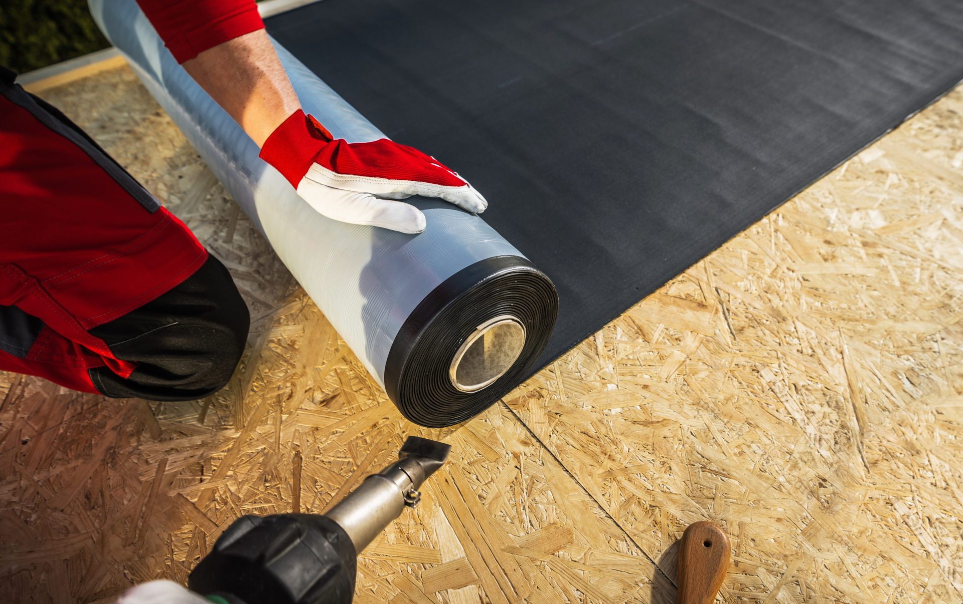 Roofer laying EPDM membrane for a new flat roof